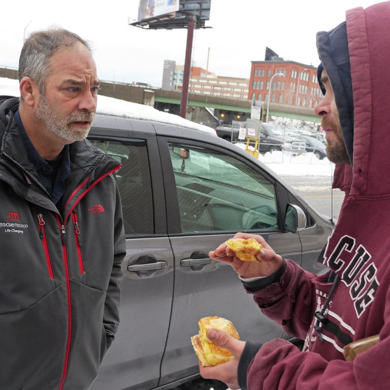 A Rescue Mission staff member providing outreach for a homeless community member